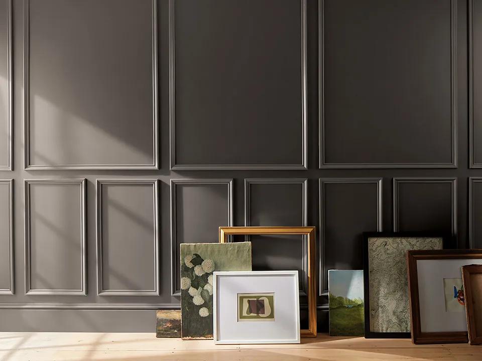 Artwork arranged against a deep chocolate brown wall painted in Silhouette AF-655